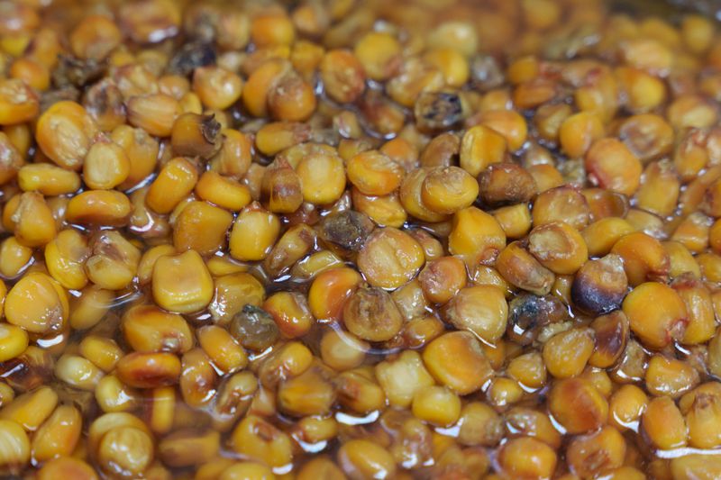 Yellow kernels of corn soaking in lime. 