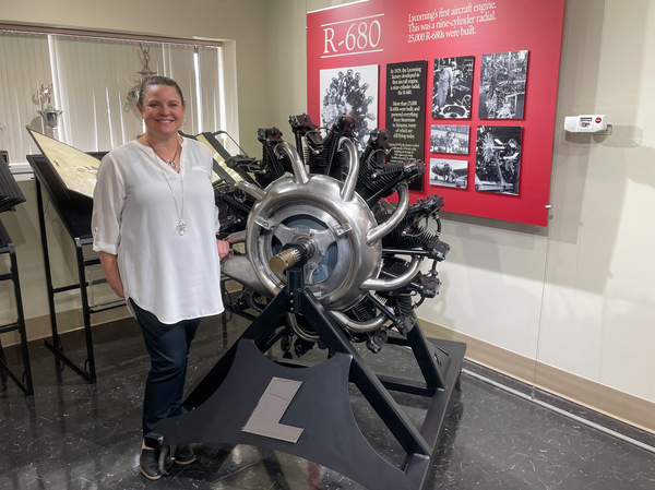 Shannon Massey, senior vice president at Lycoming Engines, next to an antique aircraft engine at the company's Williamsport factory.