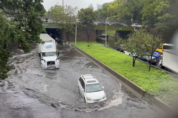 Traffic makes its way through flood waters along the Brooklyn Queens Expressway in New York in September. Climate change makes heavy rain more common, because a hotter atmosphere can hold more moisture.