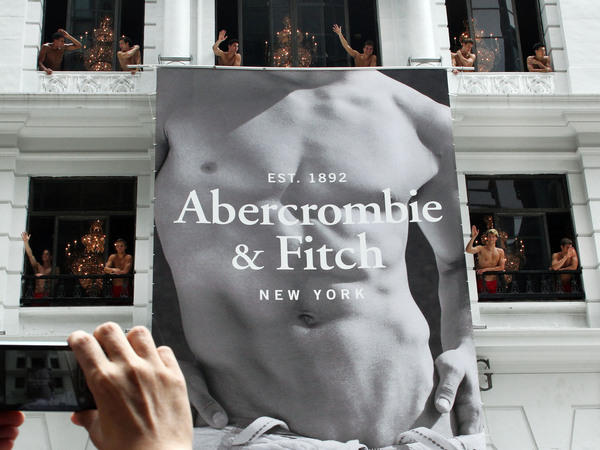 A man uses his mobile phone to take photographs of topless male models waving to a crowd of onlookers from the soon to open Abercrombie & Fitch flagship clothing store in Hong Kong in 2012.