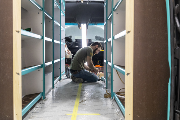 An Advanced RV employee works on a custom RV that will eventually become a mobile library.