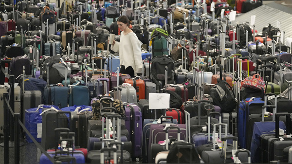 A woman walks through unclaimed bags at Southwest Airlines baggage claim at Salt Lake City International Airport on Dec. 29, 2022.