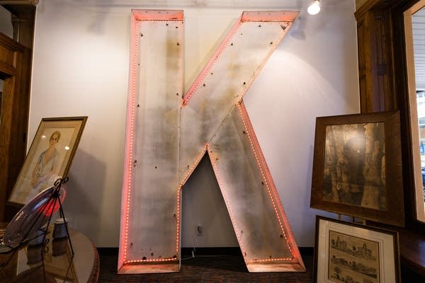A large letter K stands from floor to ceiling in a room