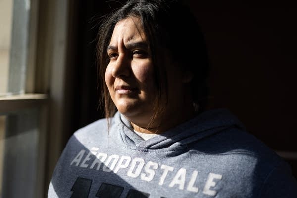 Light from a window is cast across a woman's face