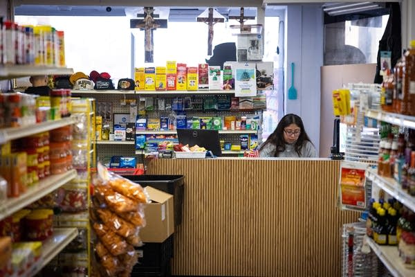 A woman sits behind a counter