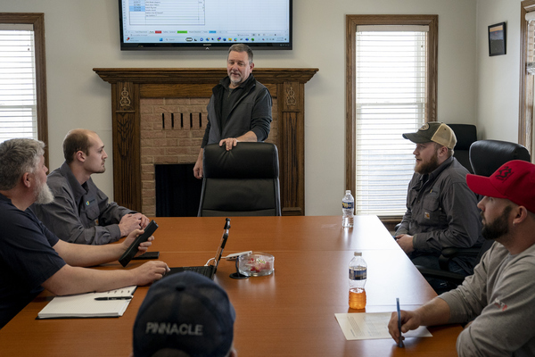 Doug Vance, middle, holds a staff meeting with technicians in February.
