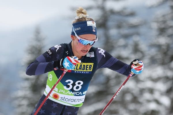 A cross country skier pushes through with ski poles.