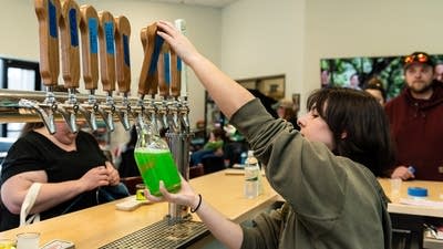 A person fills a growler