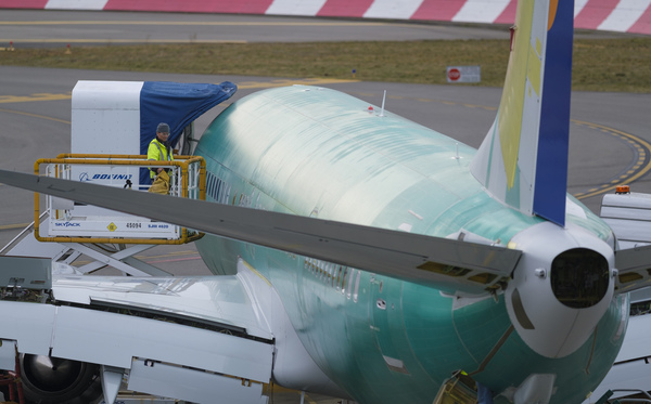 An employee checks a Boeing 737 Max 9 airplane from a lift outside the company's factory, on March 14, 2019 in Renton, Wash.