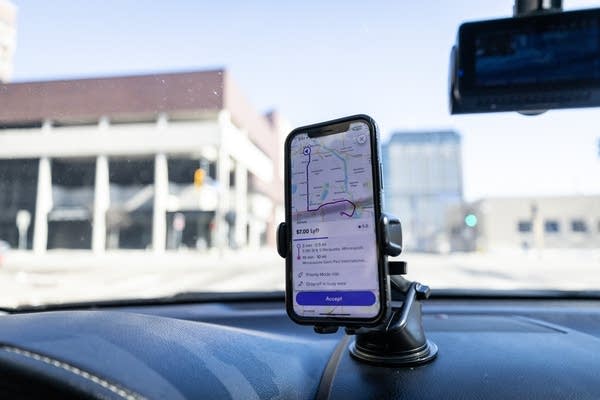 A phone sits on a dashboard car mount