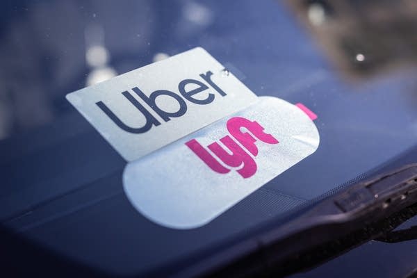 A closeup of Uber and Lyft stickers