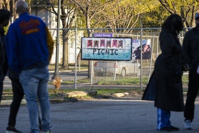 People stand near a sign reading Sammys Picnic 