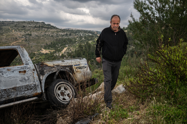 Marwan Ataya, a member of the village counsel of Kafr Ni'ma, walks away from a vehicle that was destroyed by Israeli settlers in Kafr Ni'ma in the occupied West Bank on March 24.